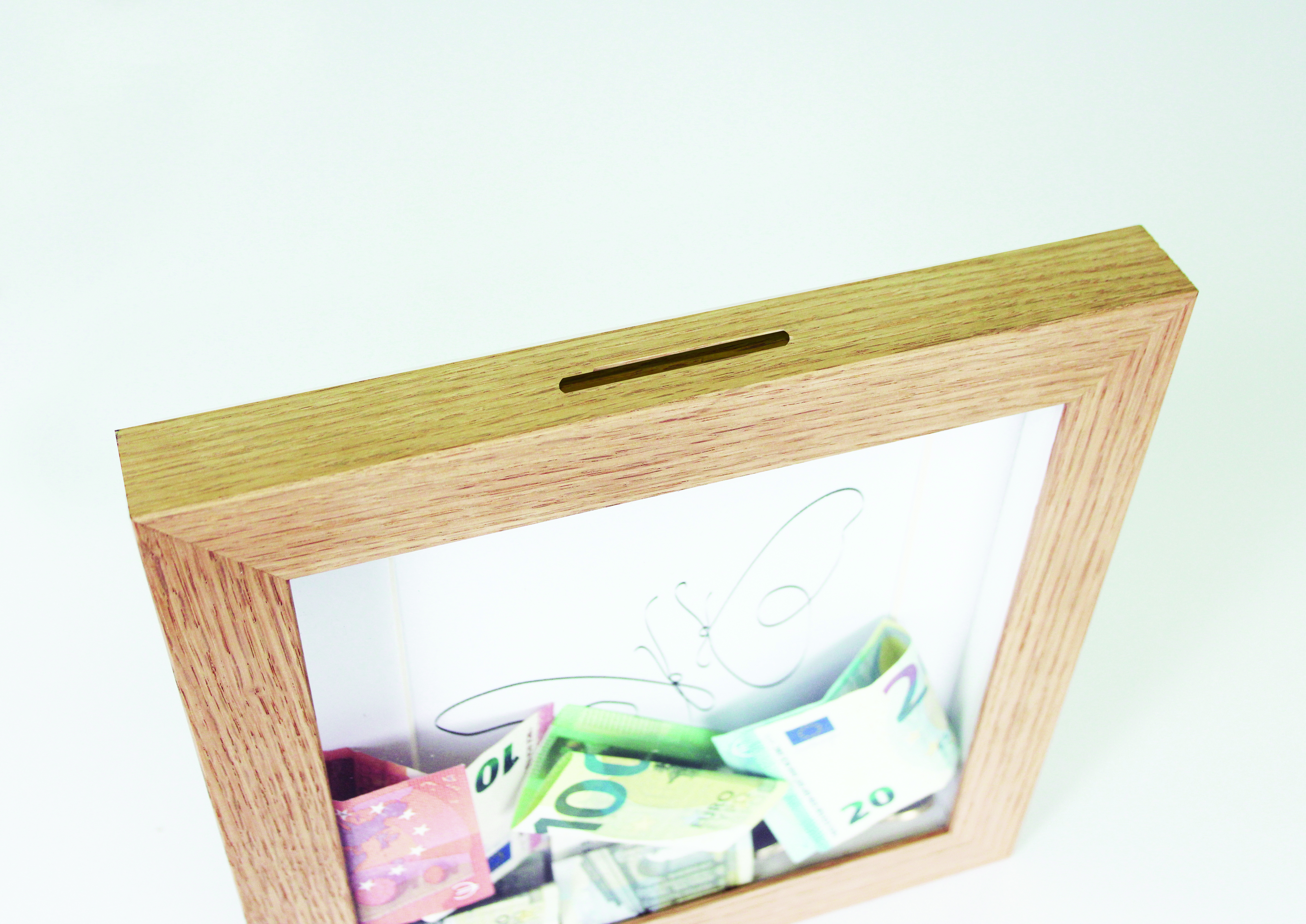 Oak wood frame made as money box, with 3D effect and slot for money, detailed top view. Picture frame producer Debex Suisse.