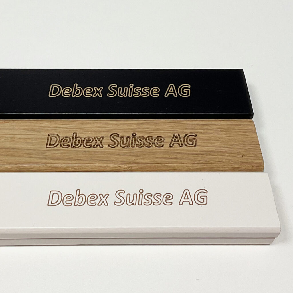 Custom engraved wooden bars in black, natural oak, and white with Debex Suisse AG logo
