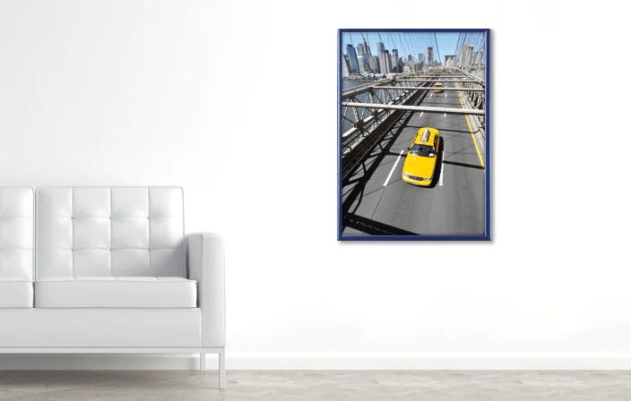 Yellow taxi cab driving on Brooklyn Bridge with New York City skyline in the background